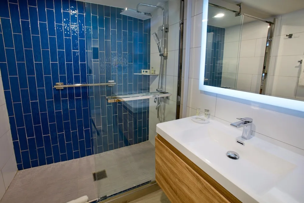 Bathroom with blue-tile walk-in shower at Divi Aruba Phoenix Beach Resort.