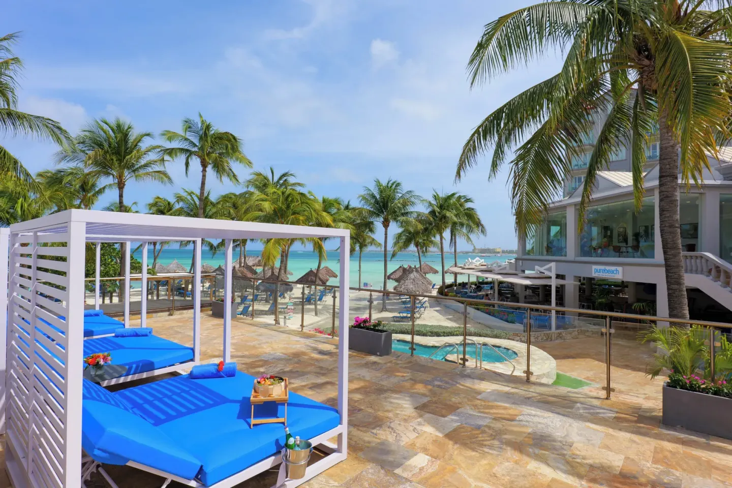 Blue cabanas overlook the beach and Purebeach at Divi Aruba Phoenix Beach Resort.