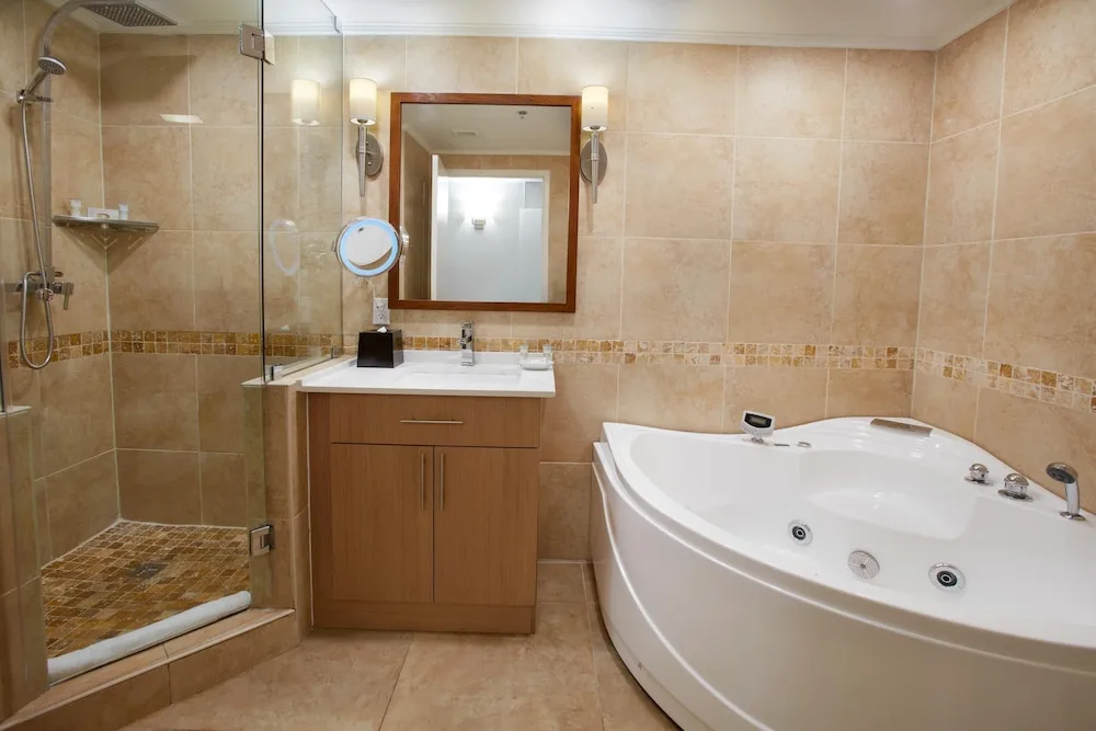 Bathroom with glass shower and jetted tub at Divi Aruba Phoenix Beach Resort.