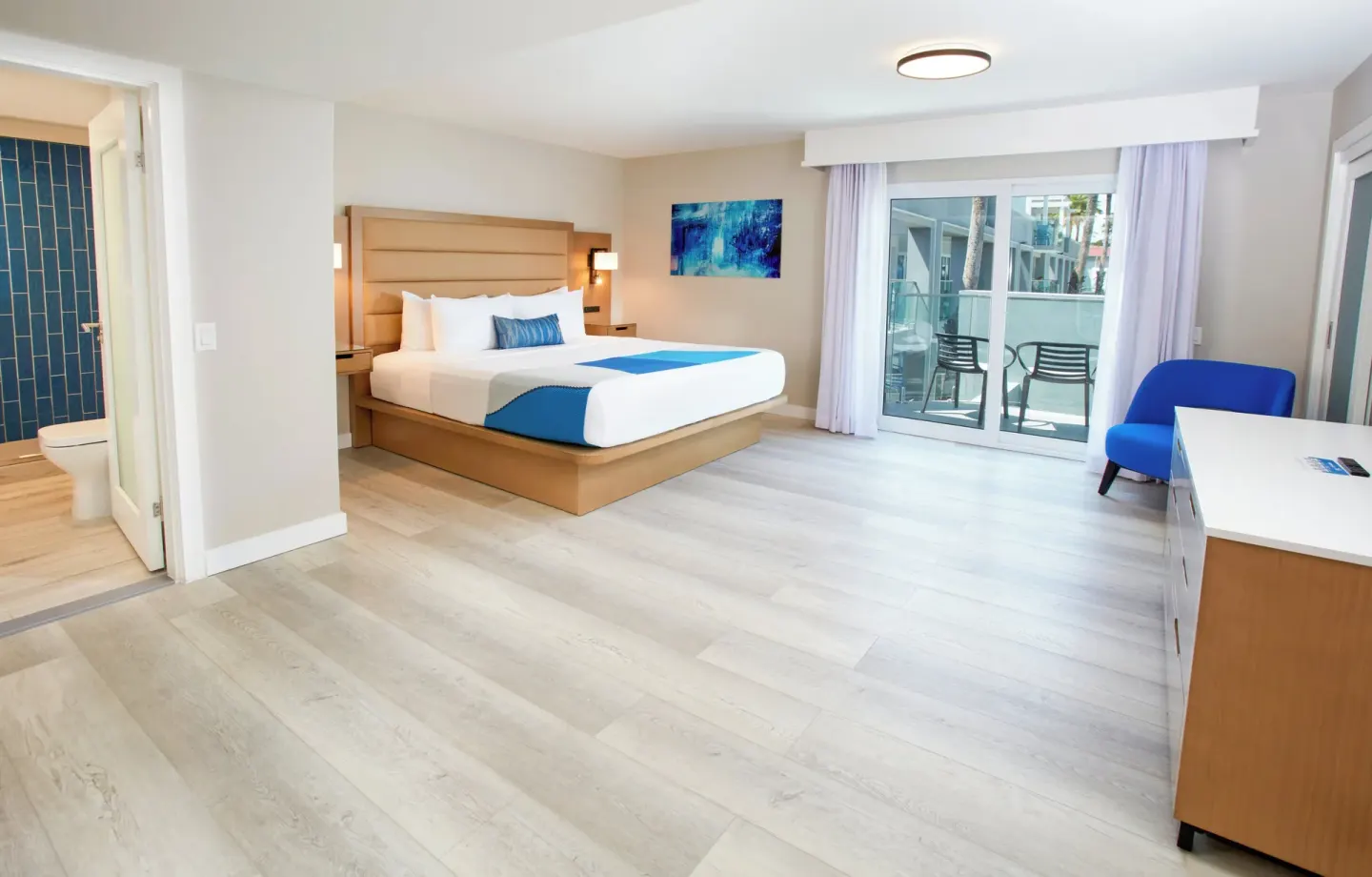Guest room with king bed and balcony seating at Divi Aruba Phoenix Beach Resort.