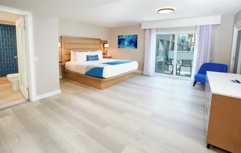 Guest room with king bed and balcony seating at Divi Aruba Phoenix Beach Resort.