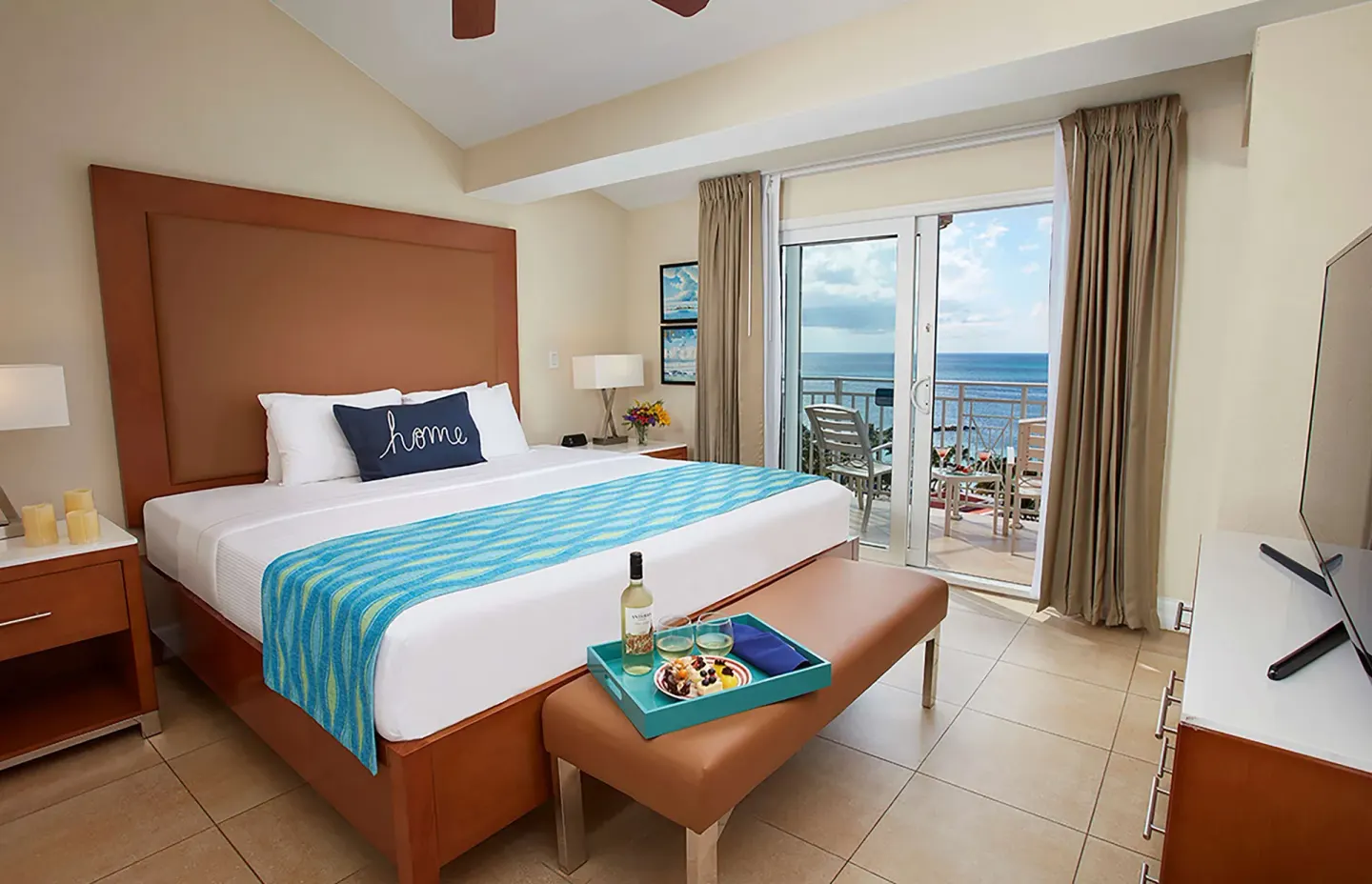 Guest room with king bed, balcony, and ocean view at Divi Aruba Phoenix Beach Resort.
