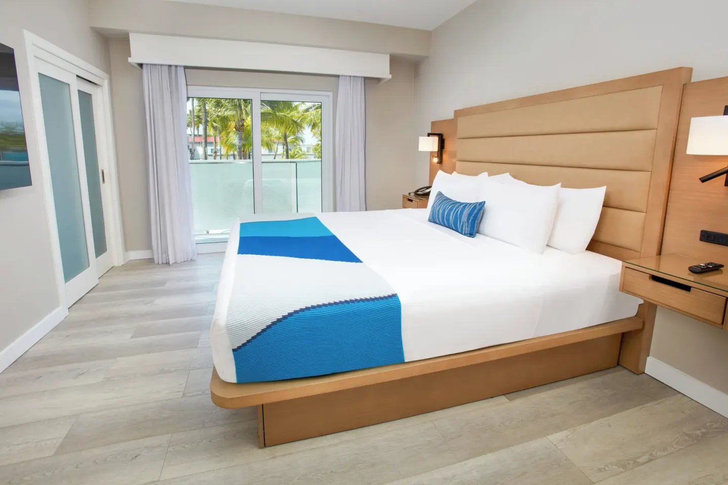 King bed guest room with palm-view balcony at Divi Aruba Phoenix Beach Resort.