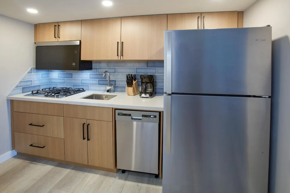 Guest suite kitchen with refrigerator and cooktop at Divi Aruba Phoenix Beach Resort.