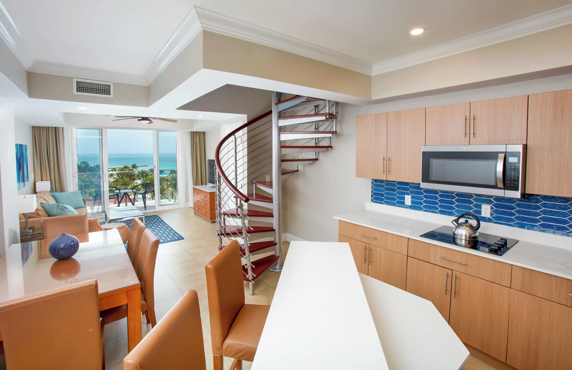 Loft suite kitchen, dining area, spiral stairs and ocean balcony at Divi Aruba Phoenix Beach Resort.
