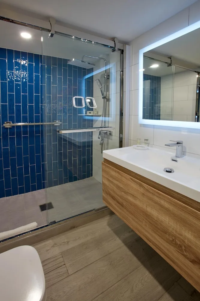 Modern bathroom with blue tile shower at Divi Aruba Phoenix Beach Resort.