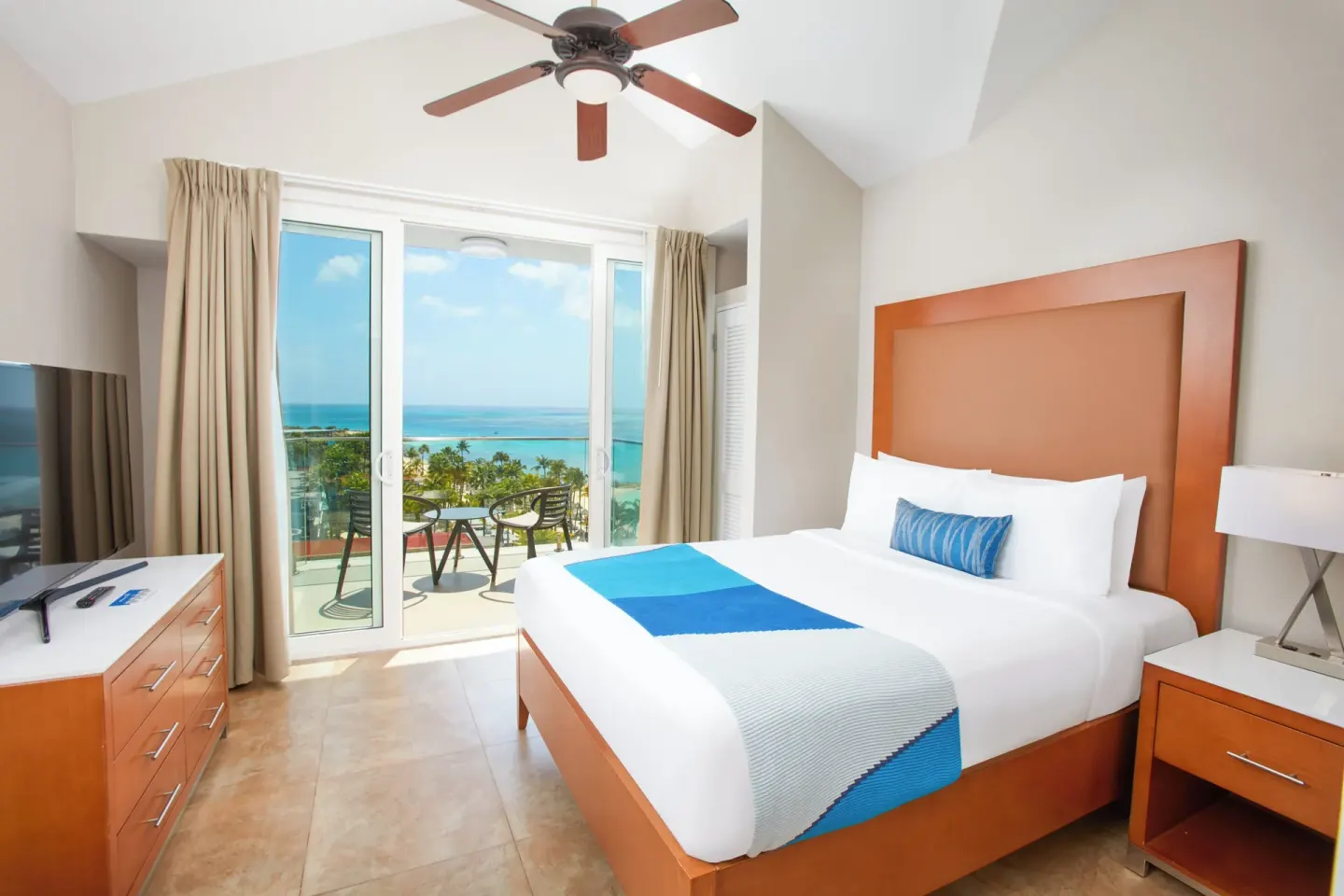 Ocean-view bedroom with king bed and balcony at Divi Aruba Phoenix Beach Resort.