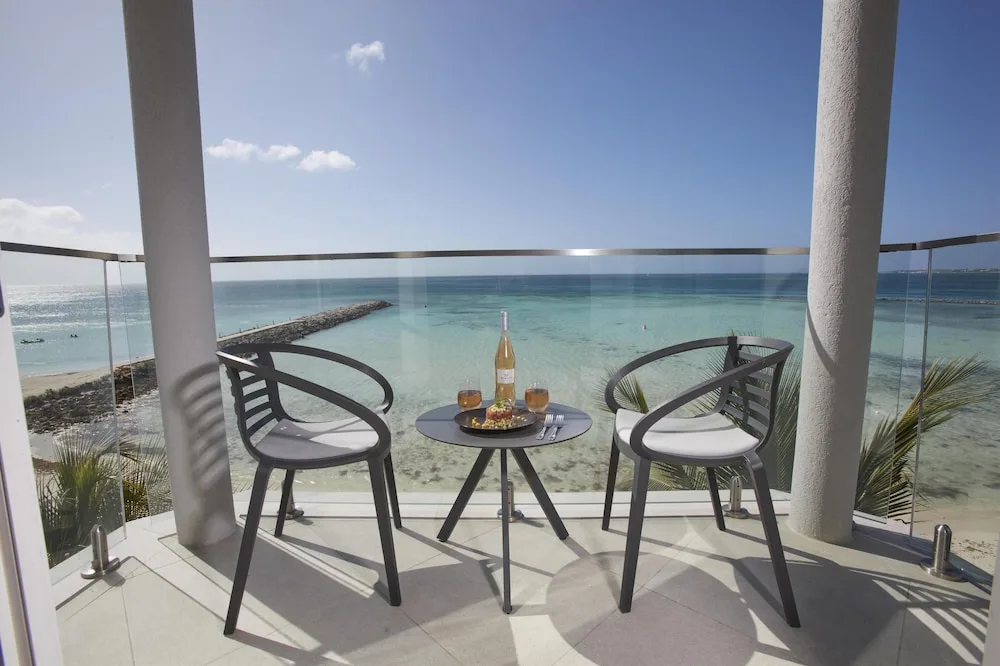 Balcony seating overlooking the beach and ocean at Divi Aruba Phoenix Beach Resort.