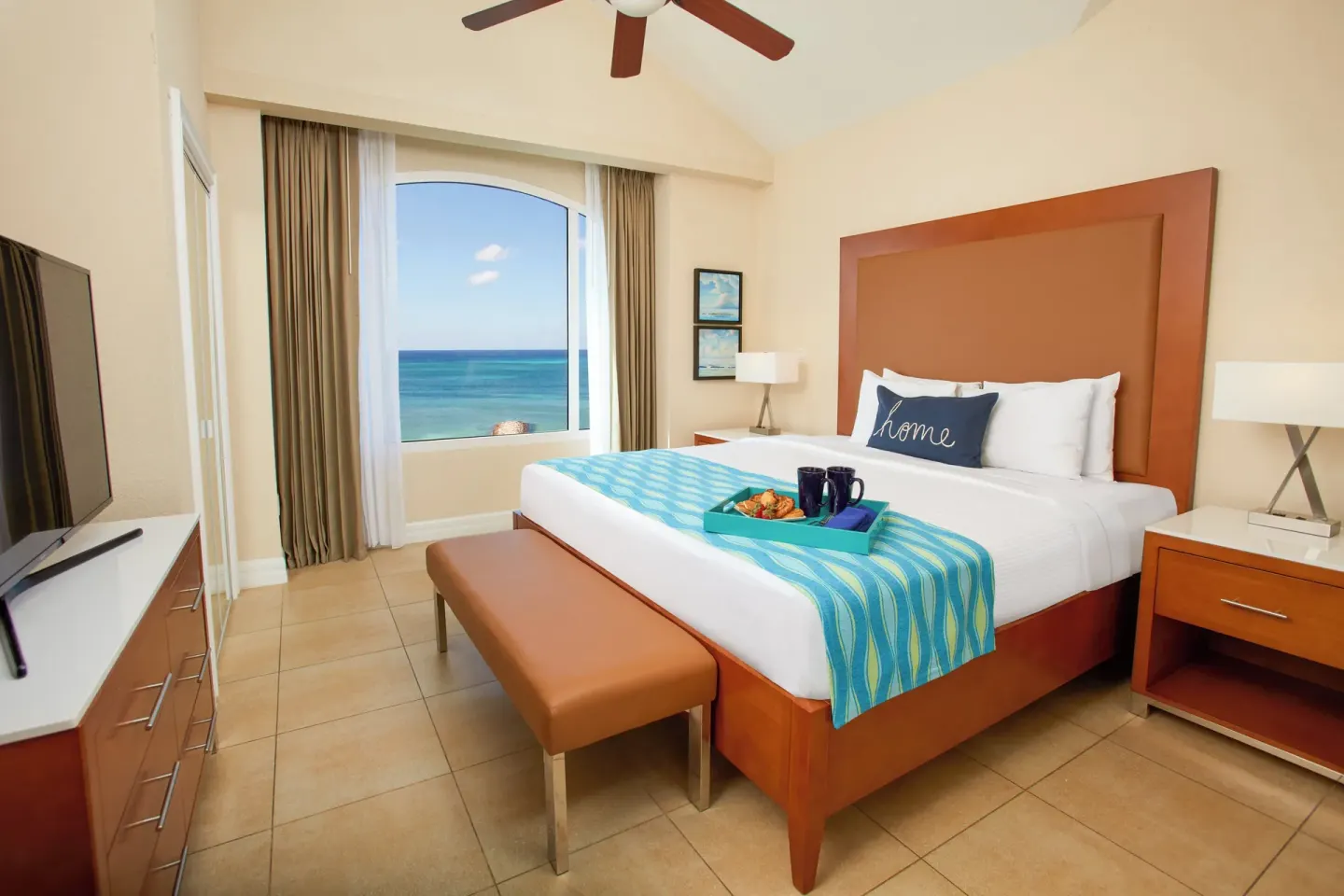 Oceanview king bedroom with arched window at Divi Aruba Phoenix Beach Resort.