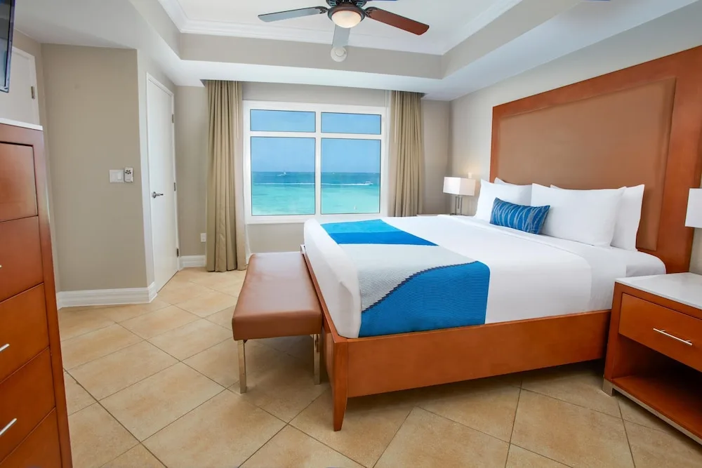 King bedroom with ocean-facing window at Divi Aruba Phoenix Beach Resort.