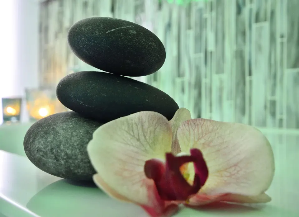 Stacked spa stones with an orchid and candles at Divi Aruba Phoenix Beach Resort.