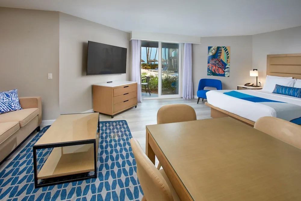 King bed studio with sofa, dining table, and patio at Divi Aruba Phoenix Beach Resort.