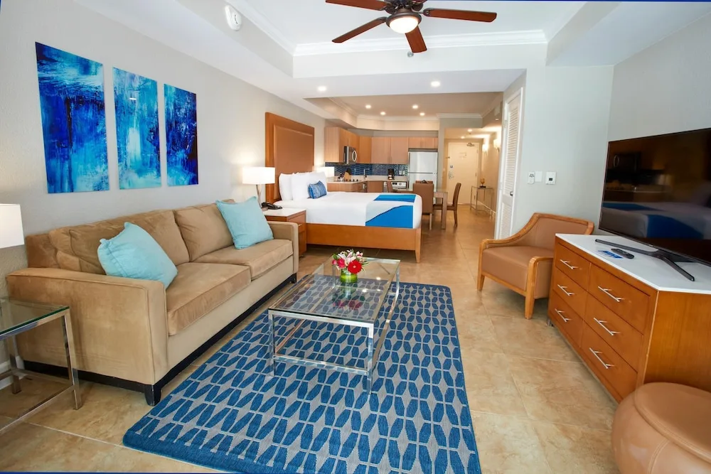 Studio-style suite with sofa, king bed, and kitchen at Divi Aruba Phoenix Beach Resort.