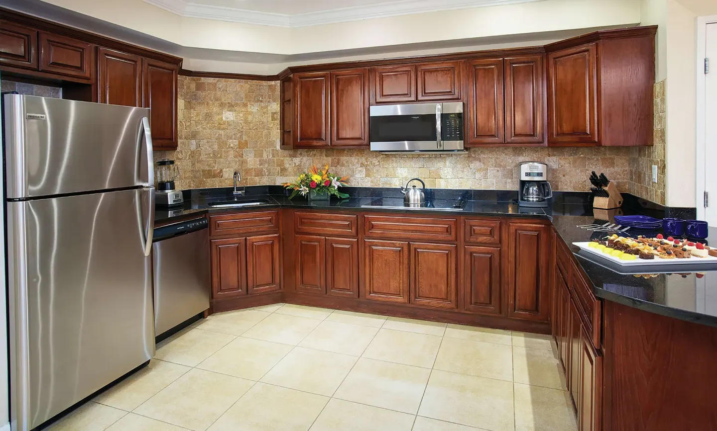 Suite kitchen with wood cabinets and stainless appliances at Divi Aruba Phoenix Beach Resort.