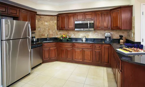 Suite kitchen with wood cabinets and stainless appliances at Divi Aruba Phoenix Beach Resort.