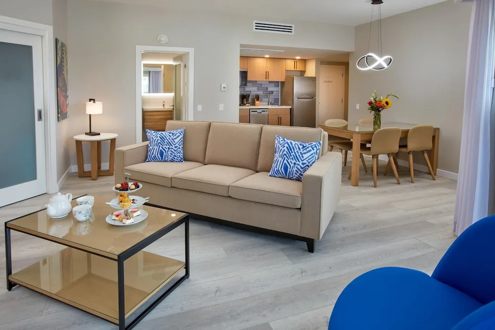 Suite living room with sofa, dining table, and kitchenette at Divi Aruba Phoenix Beach Resort.