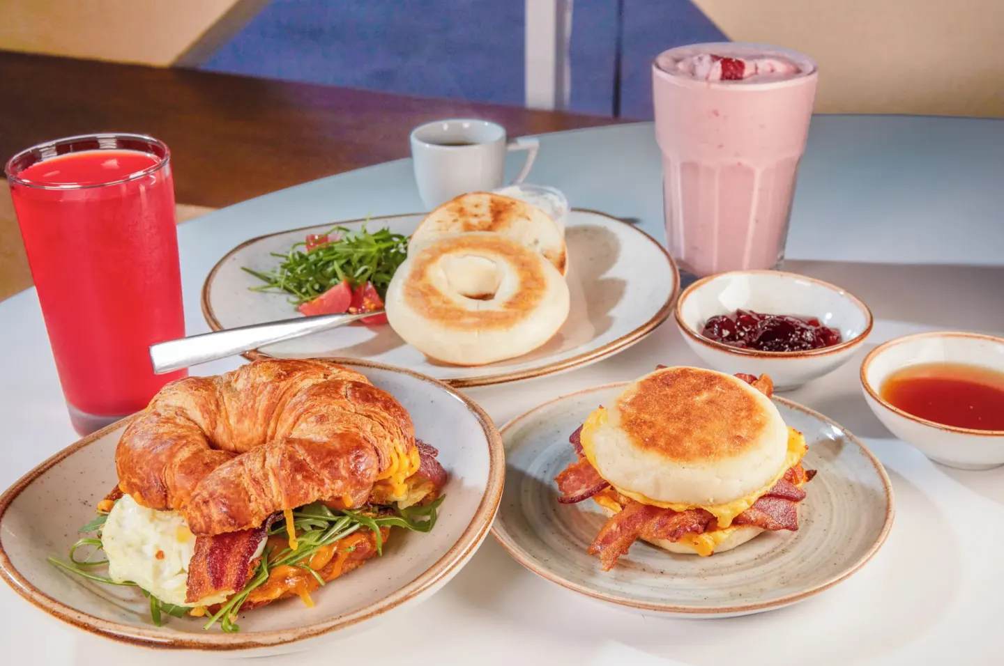 Breakfast sandwiches, bagel and drinks on a cafe table at Divi Aruba Phoenix Beach Resort.