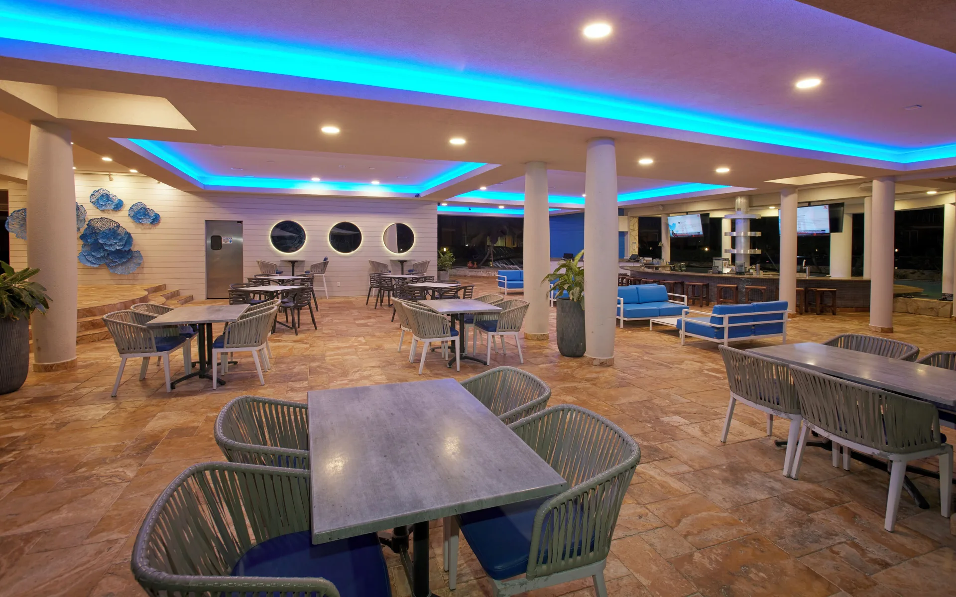 Covered dining terrace with blue ceiling lights at Divi Aruba Phoenix Beach Resort.
