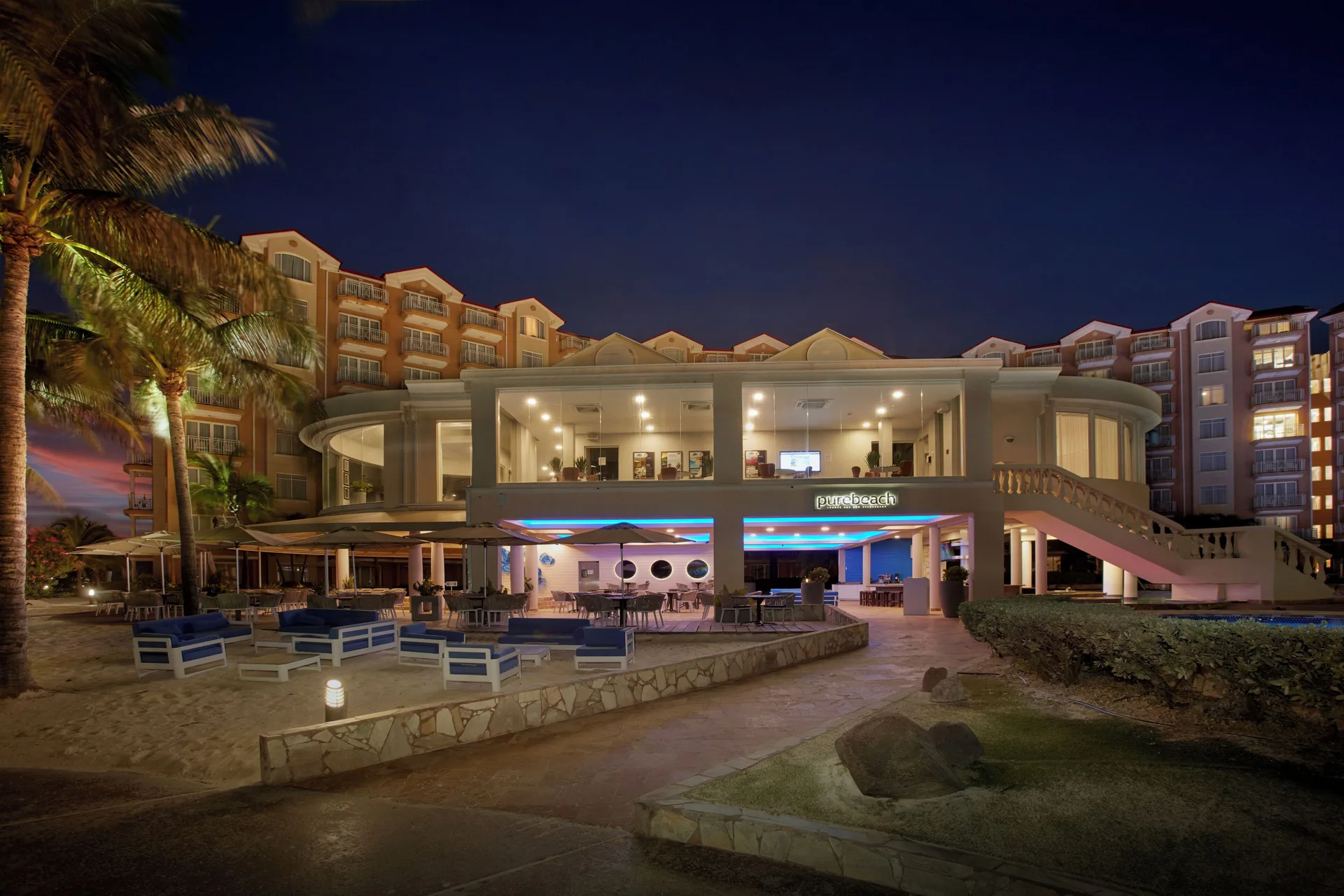 Purebeach exterior and beachfront seating at night at Divi Aruba Phoenix Beach Resort.