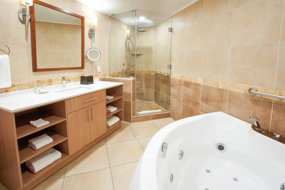 Beach Tower 1 Bedroom Suite bathroom with tub and glass shower at Divi Aruba Phoenix Beach Resort.