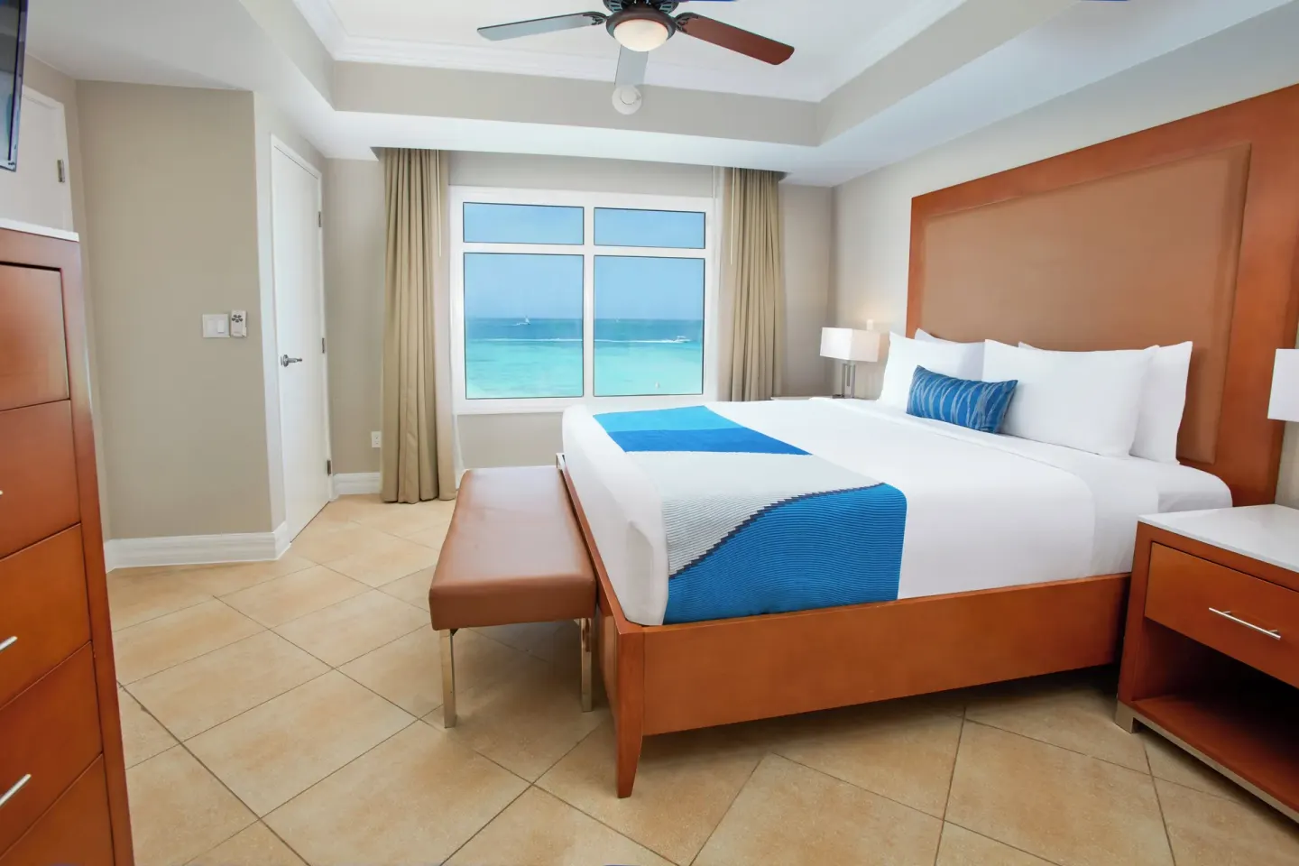 Beach Tower 1 Bedroom Suite king bed with ocean-view window at Divi Aruba Phoenix Beach Resort.