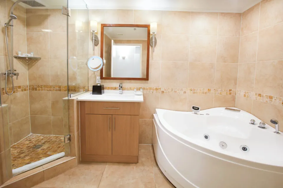 Beach Tower Studio Suite bathroom with tub and glass shower at Divi Aruba Phoenix Beach Resort.