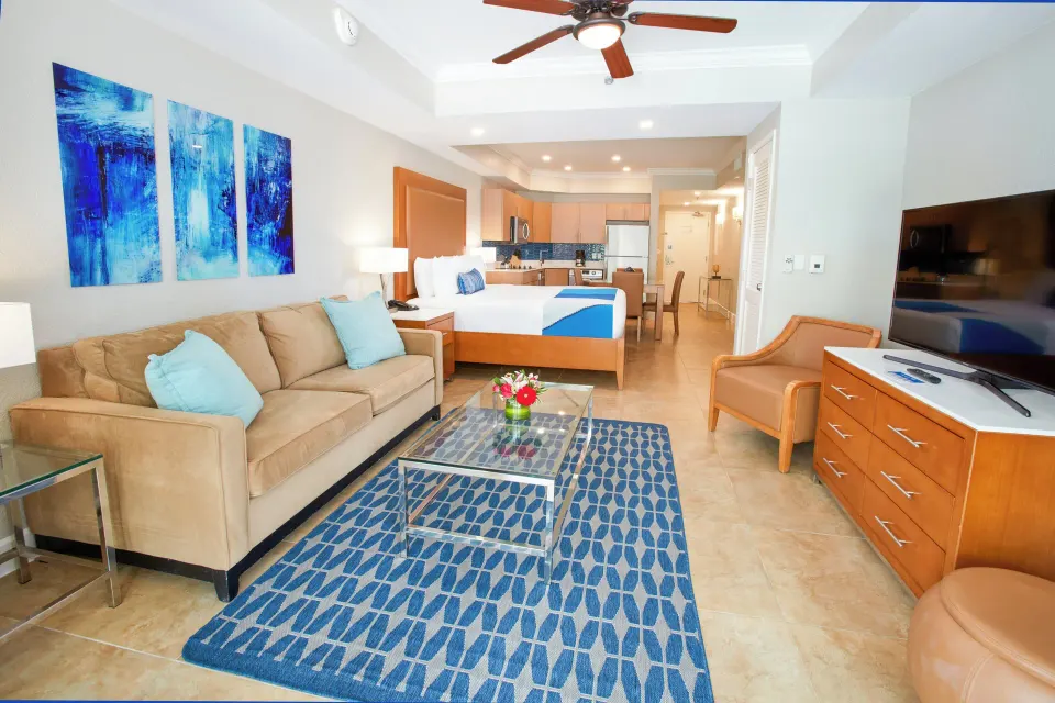 Beach Tower Studio Suite living area with sofa and king bed at Divi Aruba Phoenix Beach Resort.
