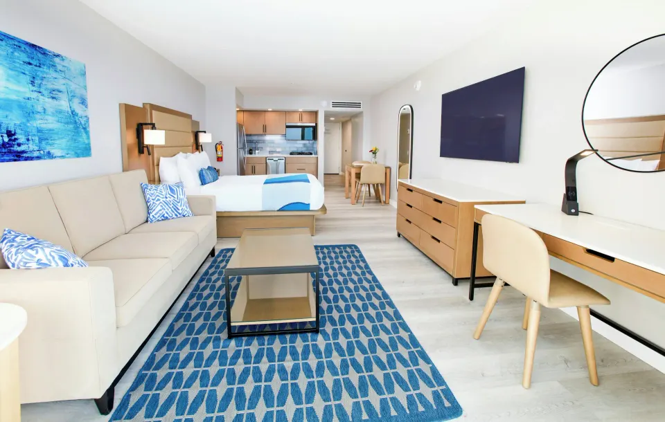 Studio Suite sofa, desk, king bed, and kitchenette at Divi Aruba Phoenix Beach Resort.