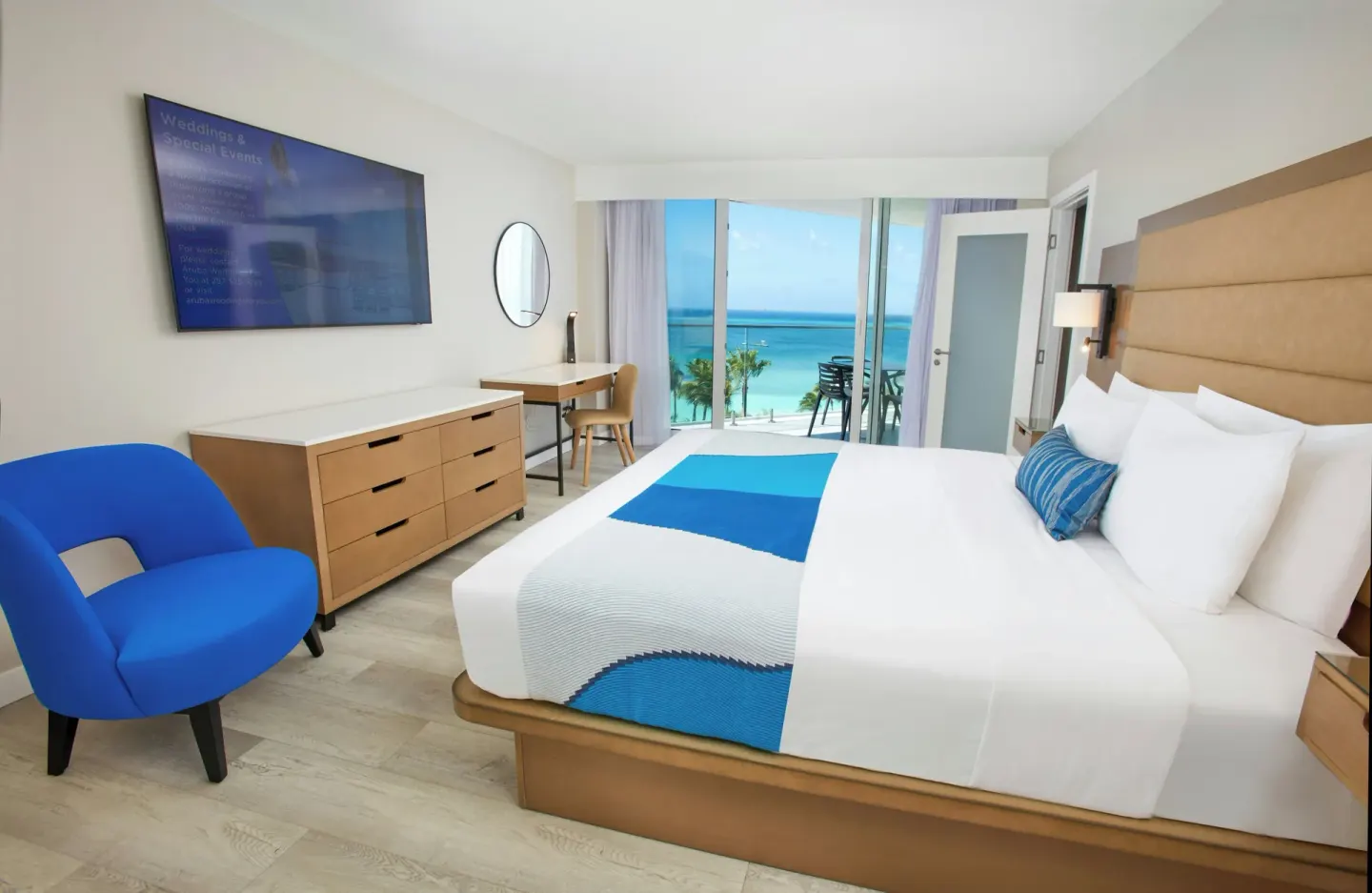 One-bedroom suite king bed with balcony ocean view at Divi Aruba Phoenix Beach Resort.