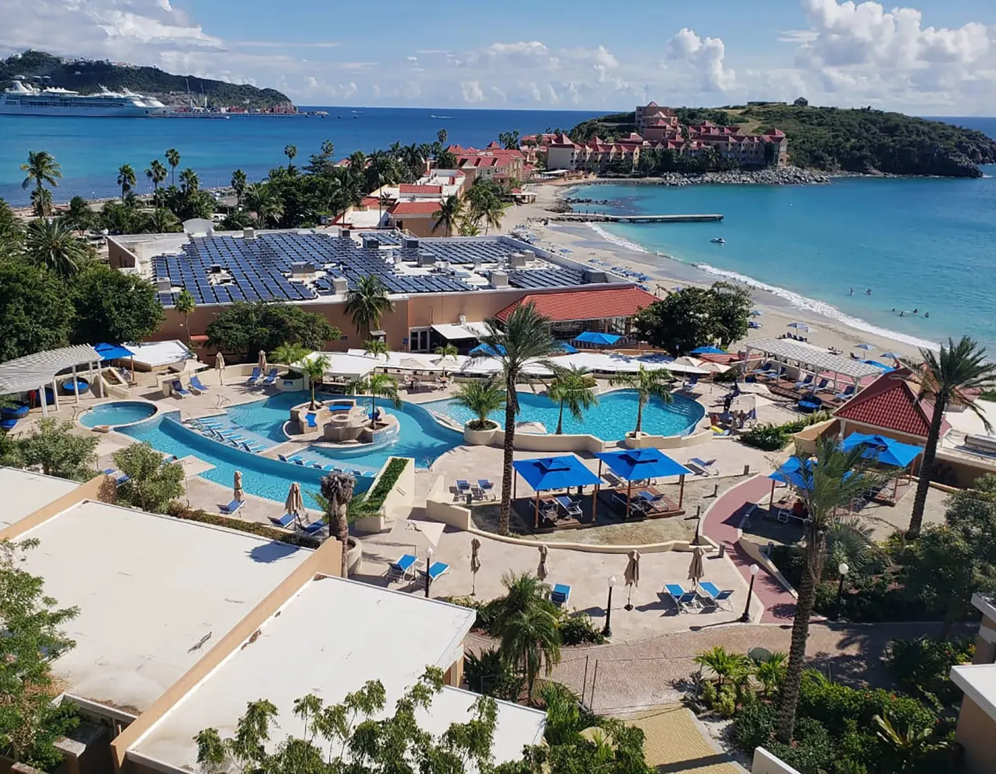 Aerial view of pools, beach, and bay at Divi Little Bay Beach Resort.