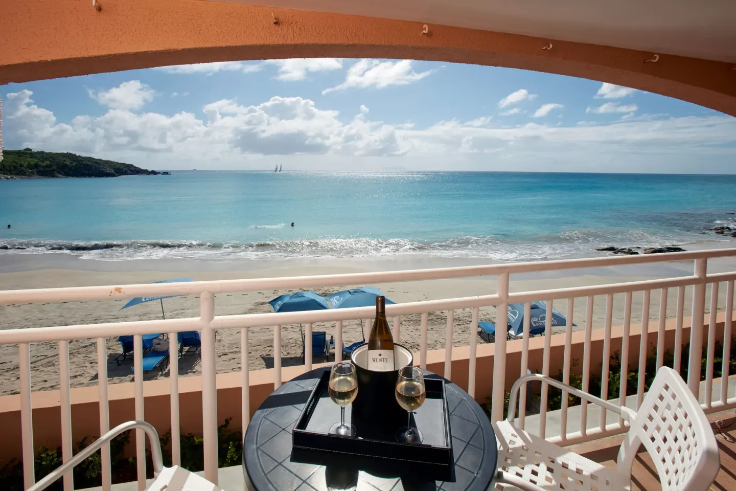 Beachfront balcony with table, chairs, and ocean view at Divi Little Bay Beach Resort.