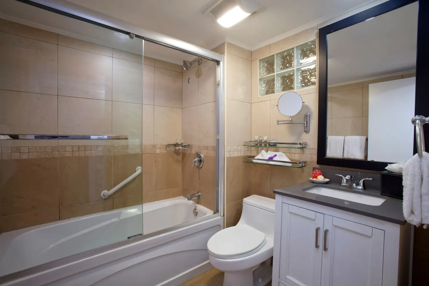 Guest bathroom with shower-tub combo and white vanity at Divi Little Bay Beach Resort.