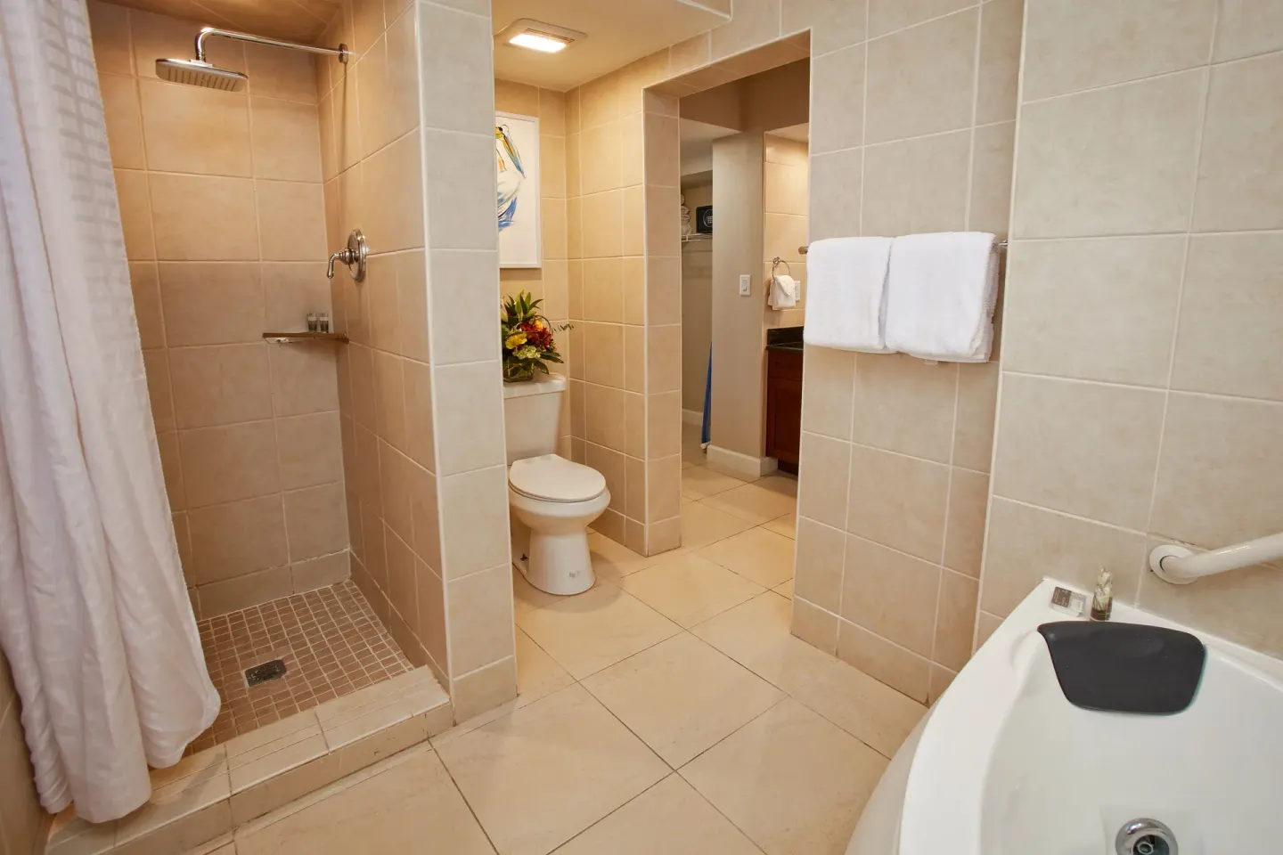 Guest bathroom with walk-in shower and tub at Divi Little Bay Beach Resort.