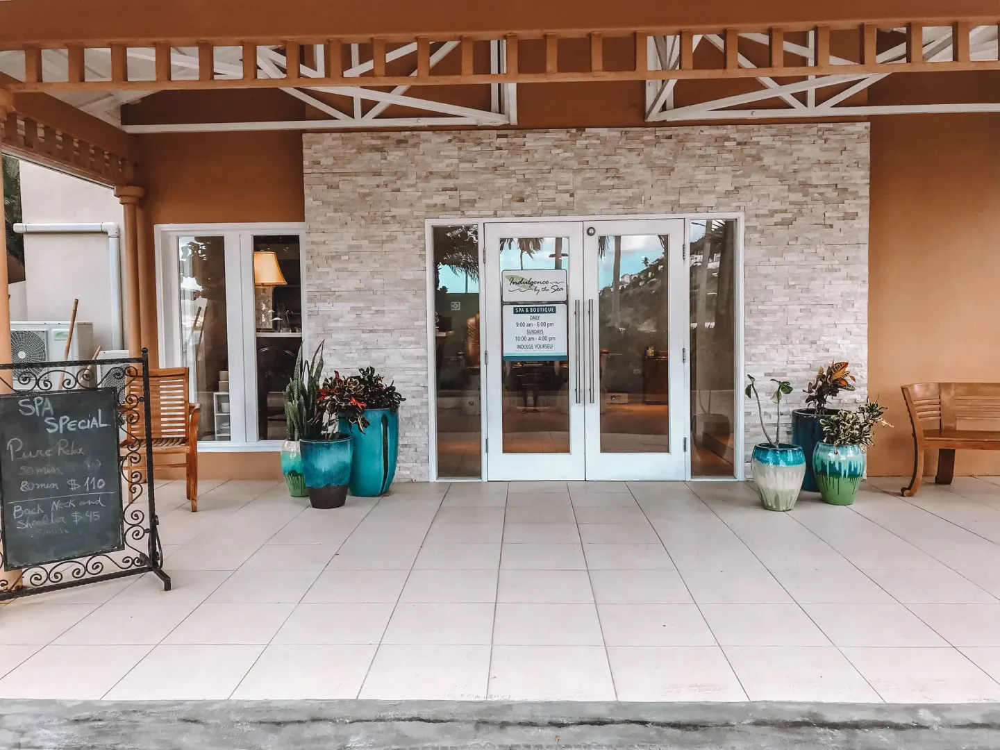 Spa entrance with planters and a specials board at Divi Little Bay Beach Resort.