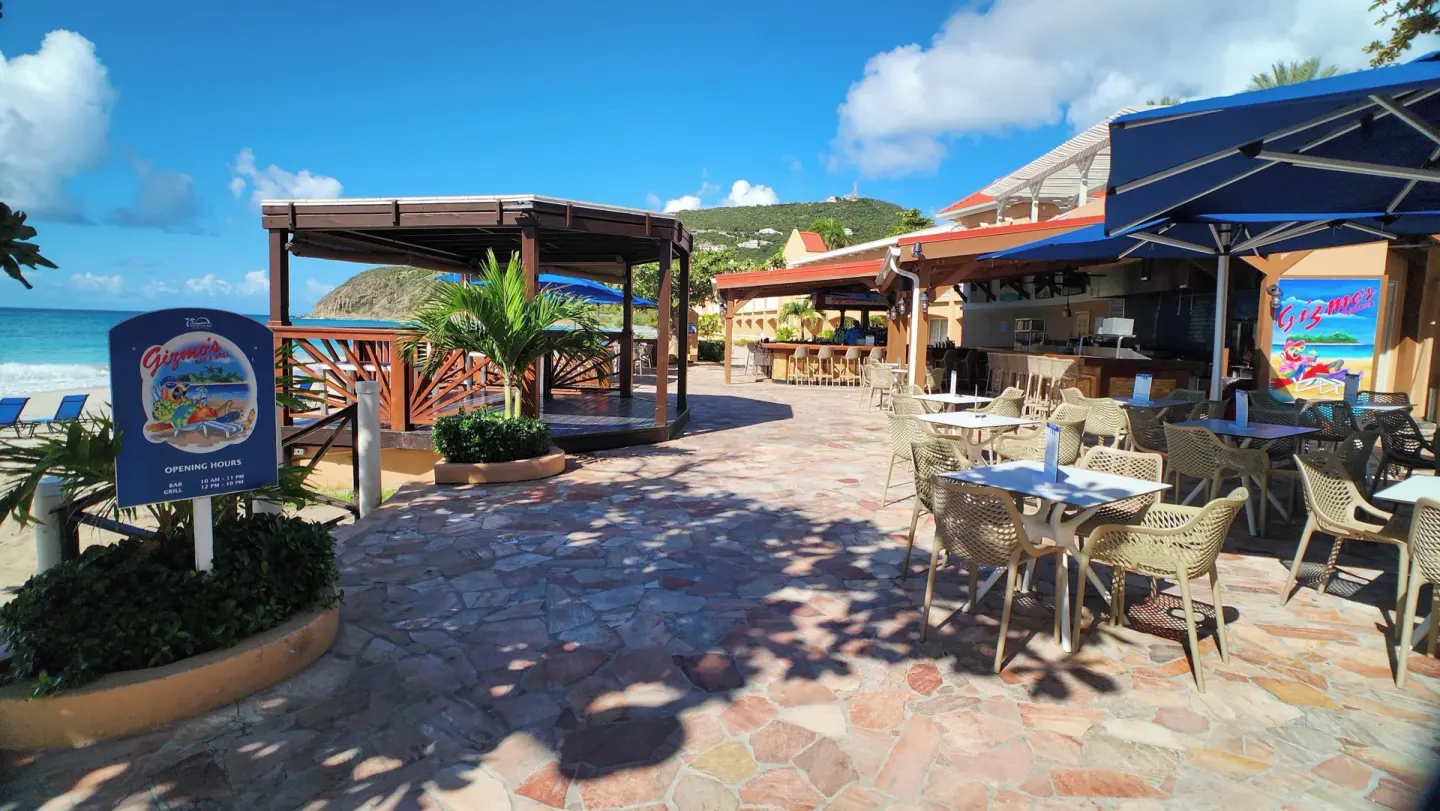 Beachfront tables and Gizmo's signage at Divi Little Bay Beach Resort.