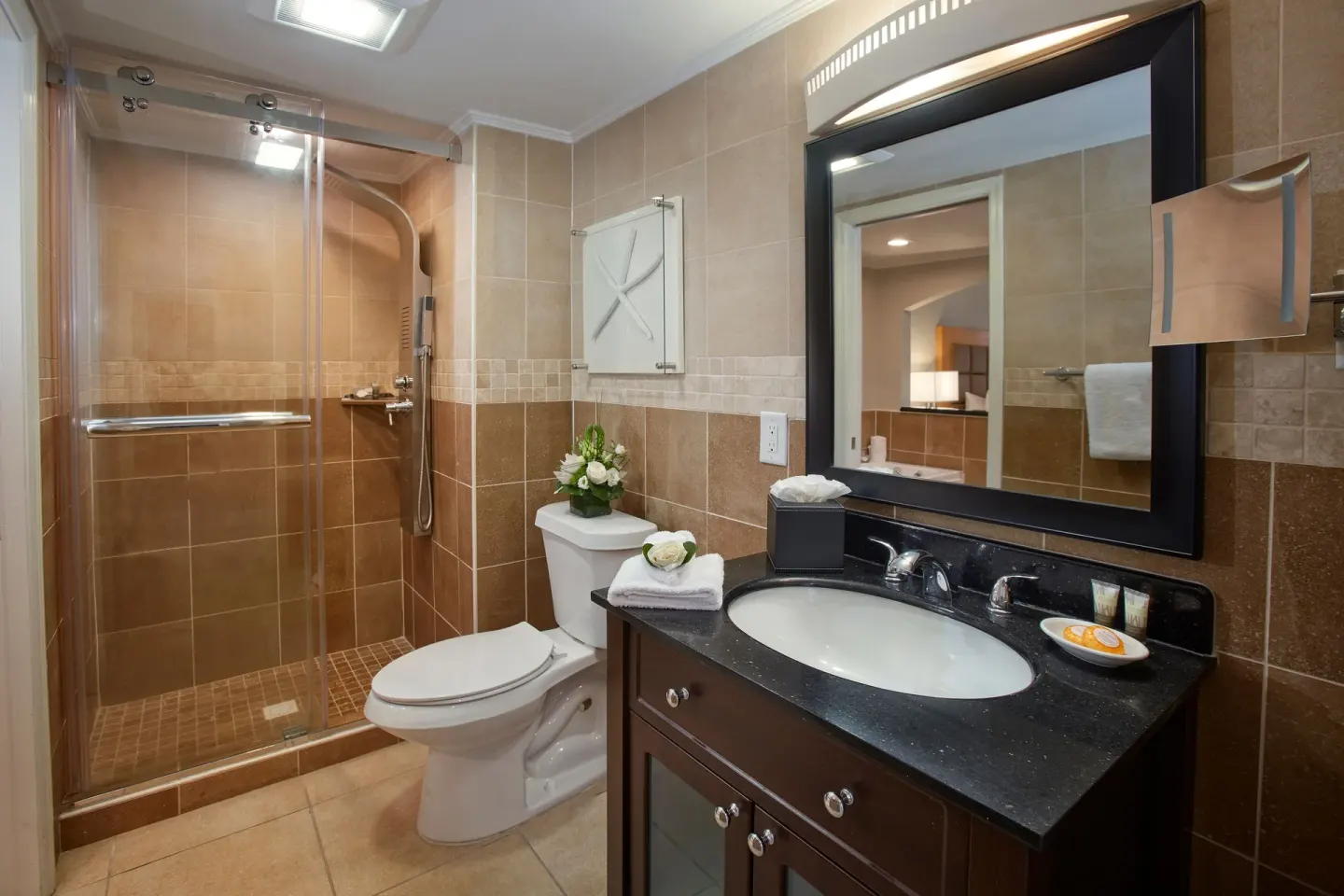 One-bedroom suite bathroom with glass shower and vanity at Divi Little Bay Beach Resort.