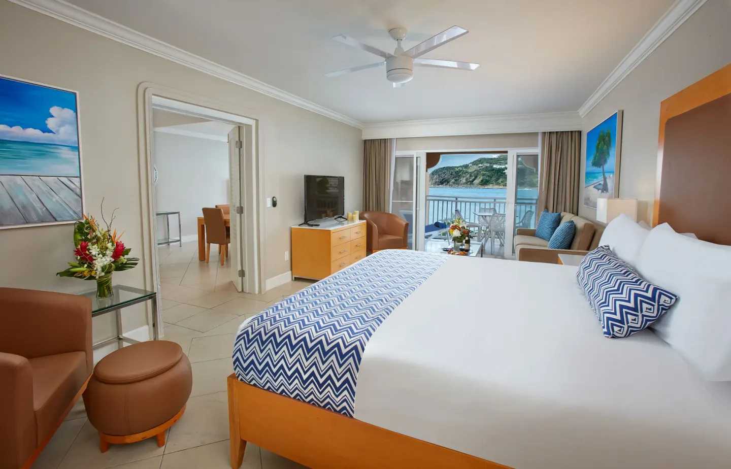 One-bedroom suite king bed with balcony seating and bay view at Divi Little Bay Beach Resort.