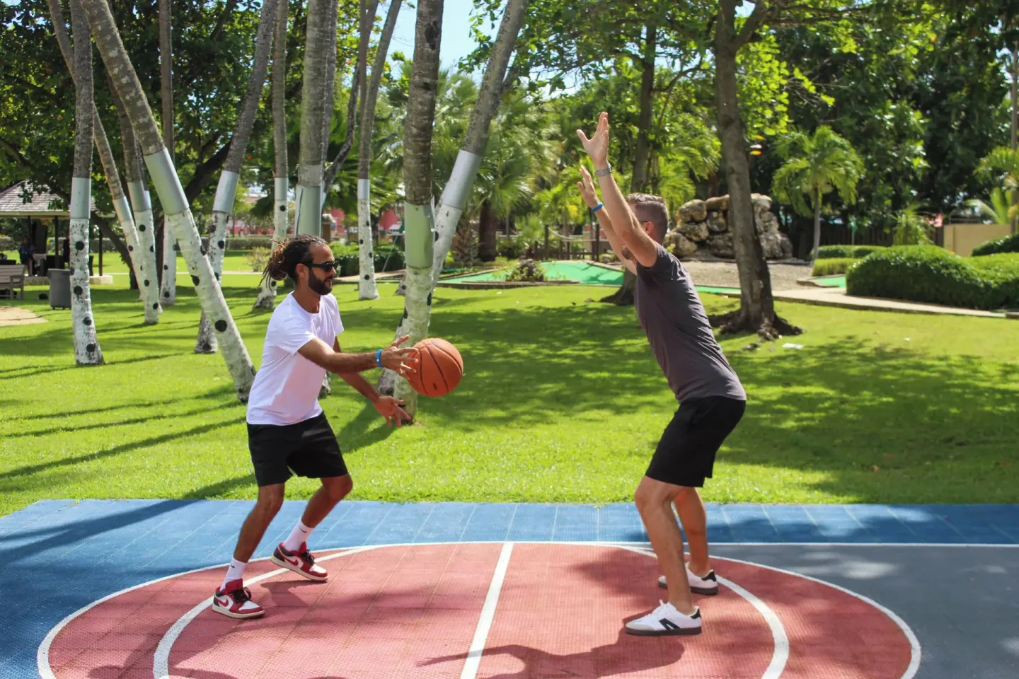 Guests playing basketball near palms and lawns at Divi Southwinds Beach Resort.