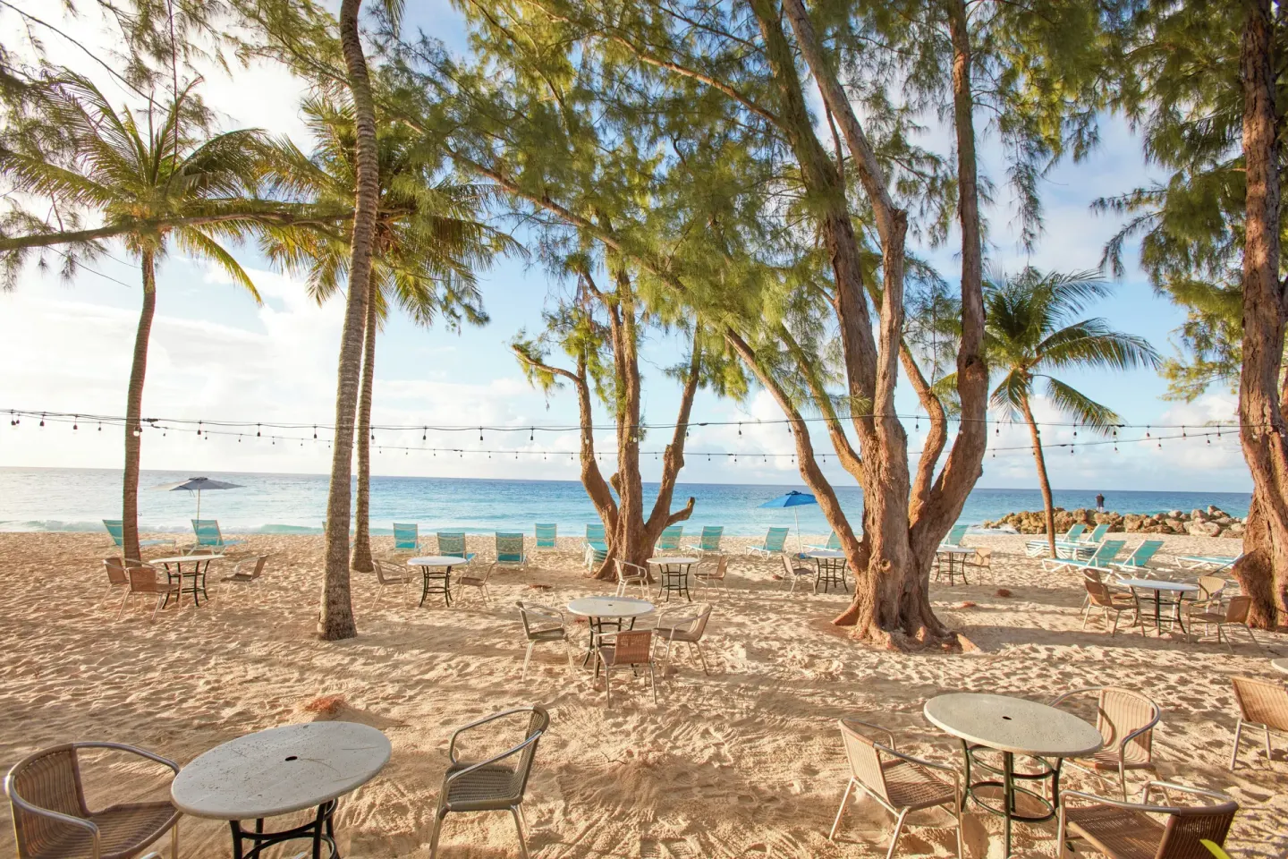Beach seating, string lights, and trees face the ocean at Divi Southwinds Beach Resort.