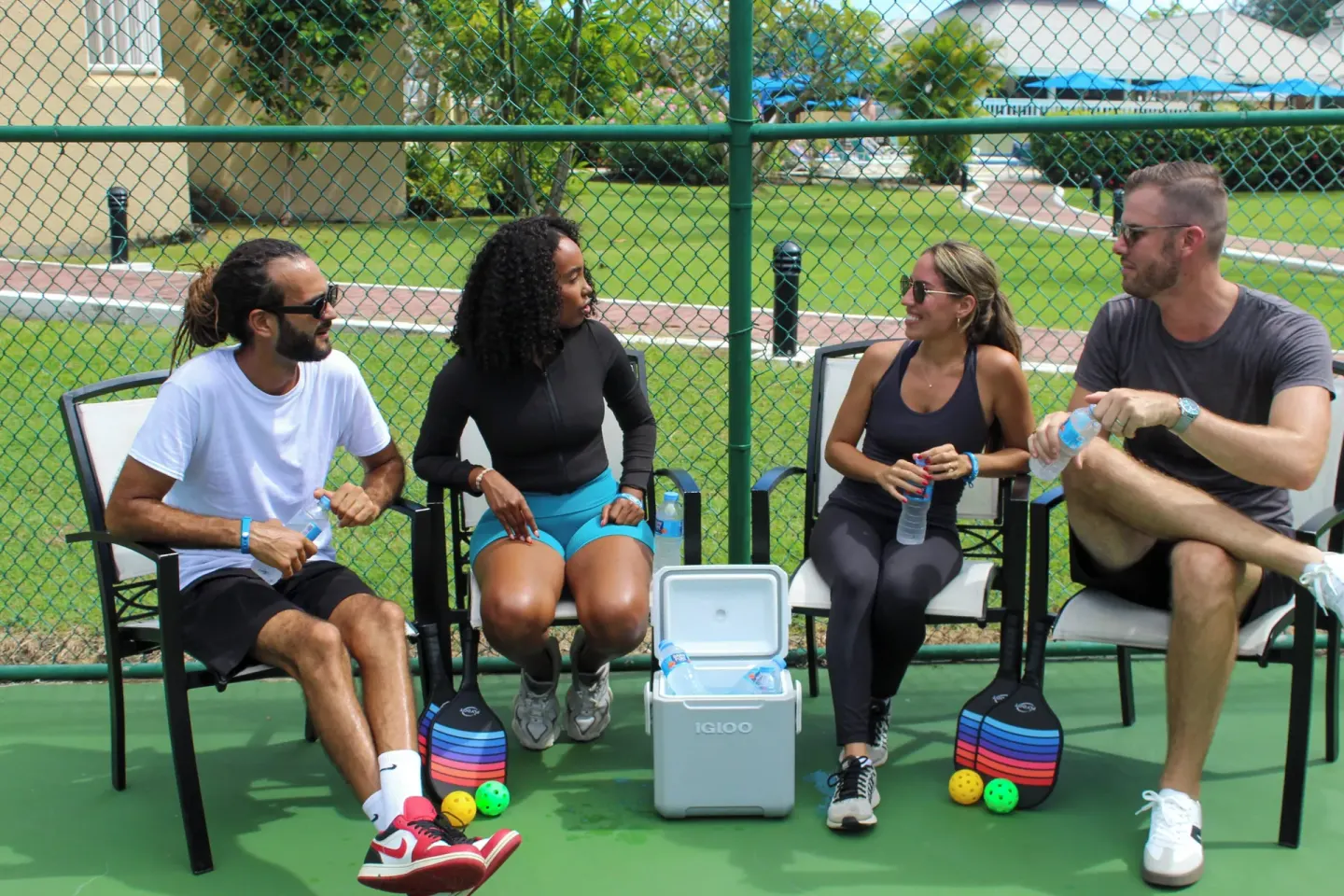 Guests sitting beside a court with paddles and drinks at Divi Southwinds Beach Resort.