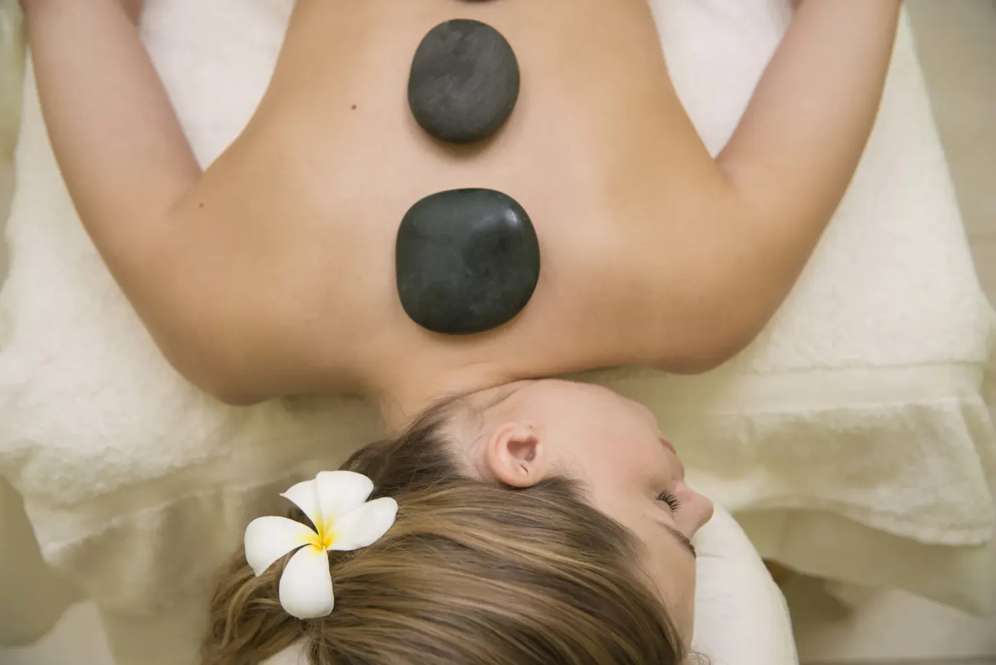 Hot stone spa treatment with a flower accent at Divi Southwinds Beach Resort.