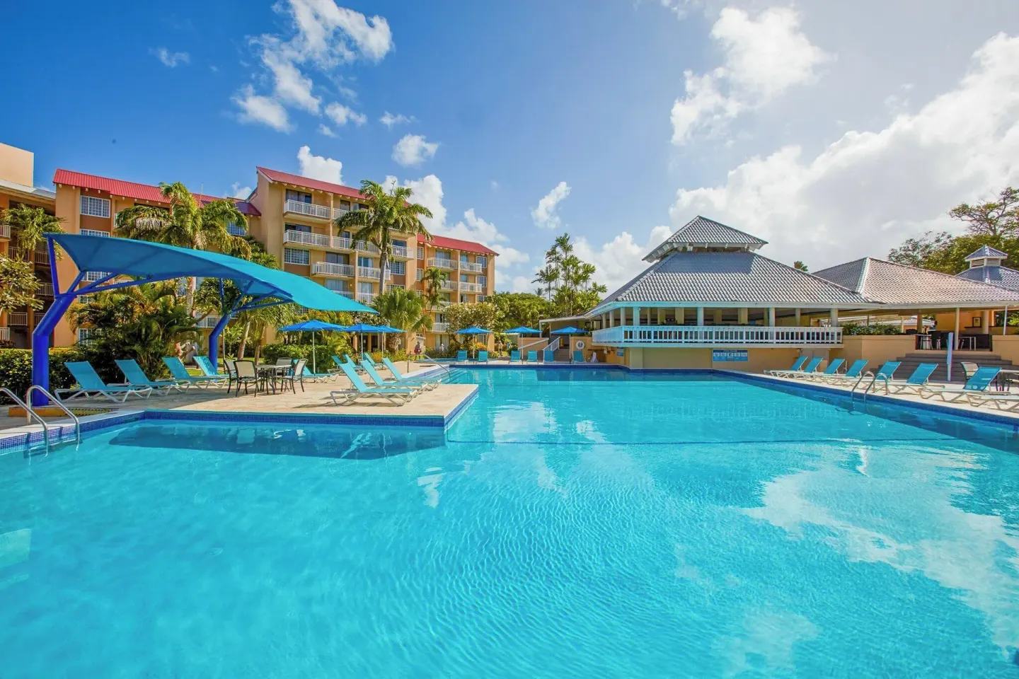 Large resort pool with shade canopies and nearby buildings at Divi Southwinds Beach Resort.