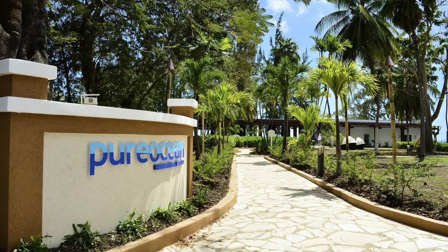Pureocean sign beside a palm-lined walkway at Divi Southwinds Beach Resort.