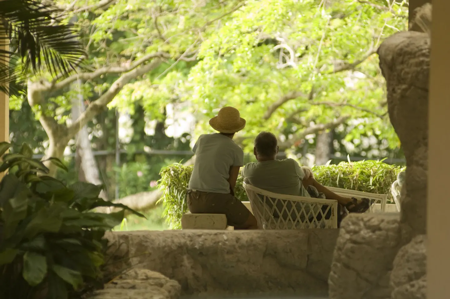 Two guests sit on a shaded garden terrace at Divi Southwinds Beach Resort.
