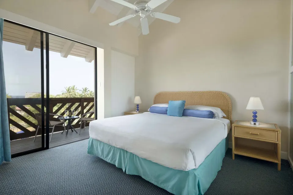 One-Bedroom Garden View Suite bedroom with king bed and balcony at Divi Southwinds Beach Resort.