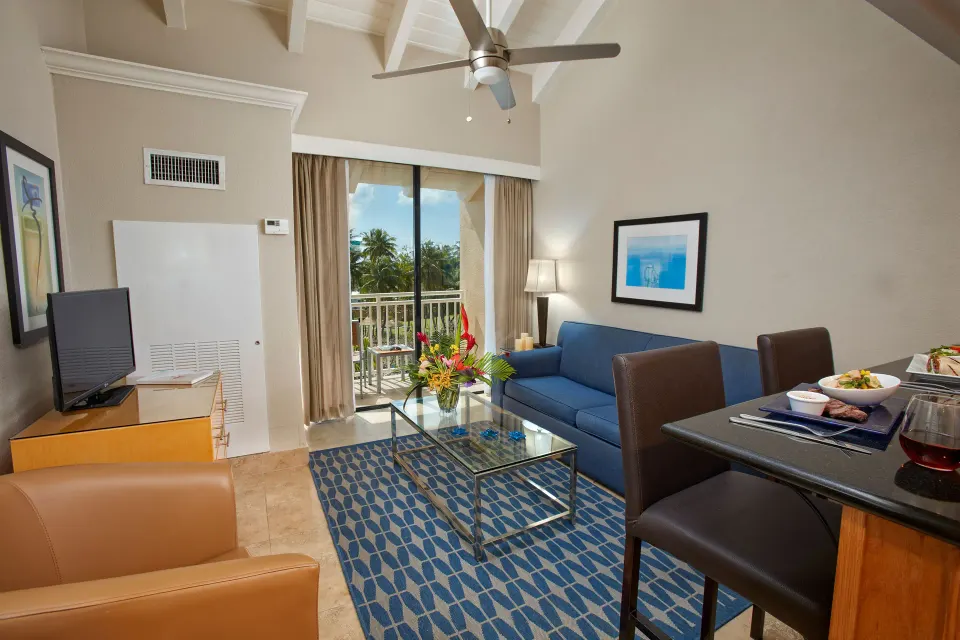 One-bedroom garden view suite living area with balcony at Divi Southwinds Beach Resort.