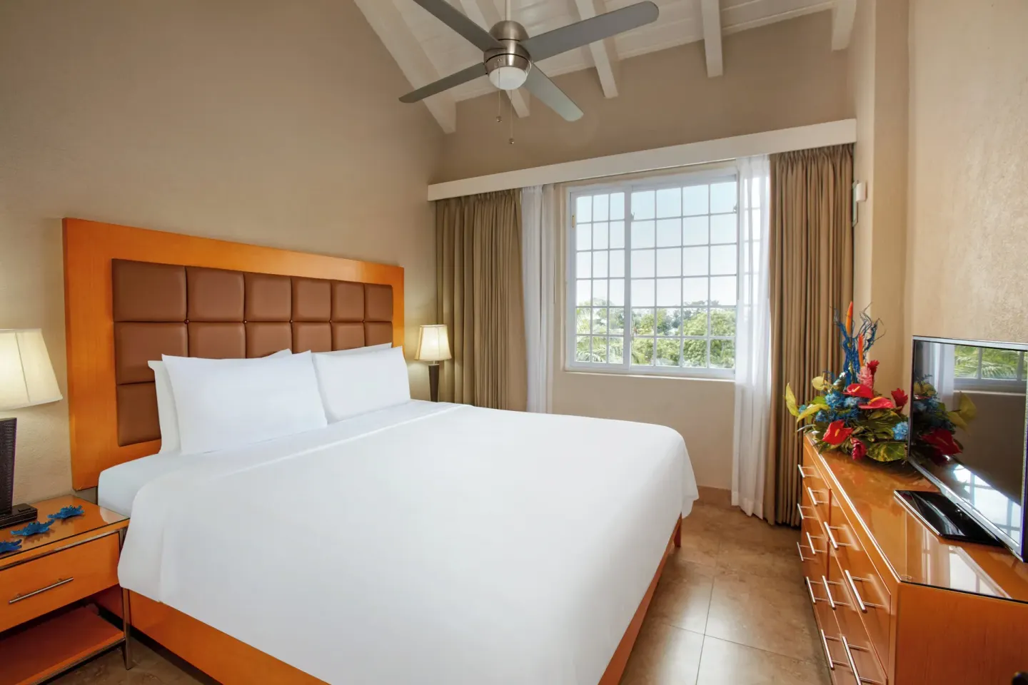 One-bedroom pool-view suite bedroom with king bed at Divi Southwinds Beach Resort.