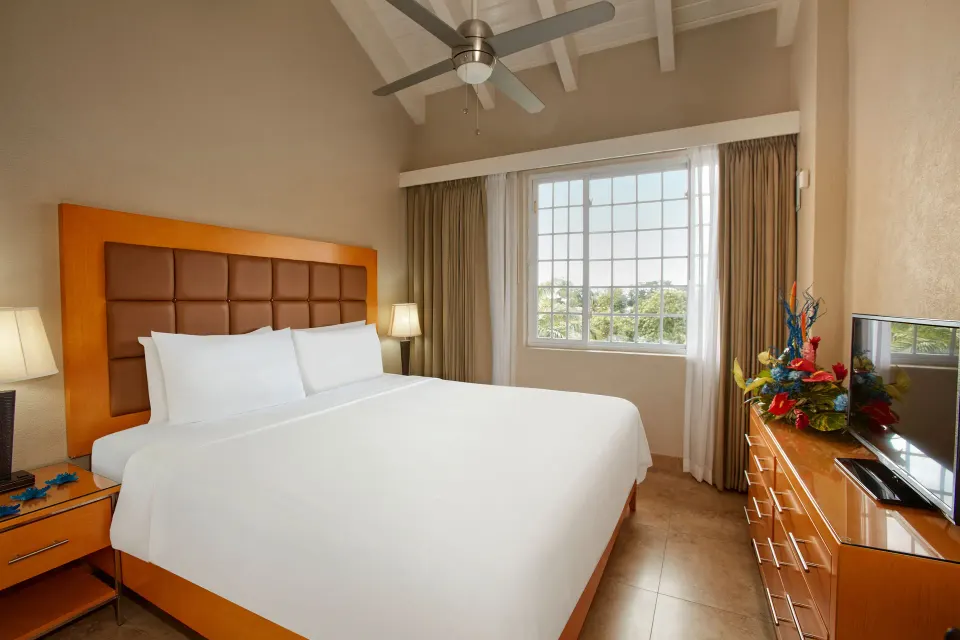 King bedroom with window and dresser in a pool view suite at Divi Southwinds Beach Resort.