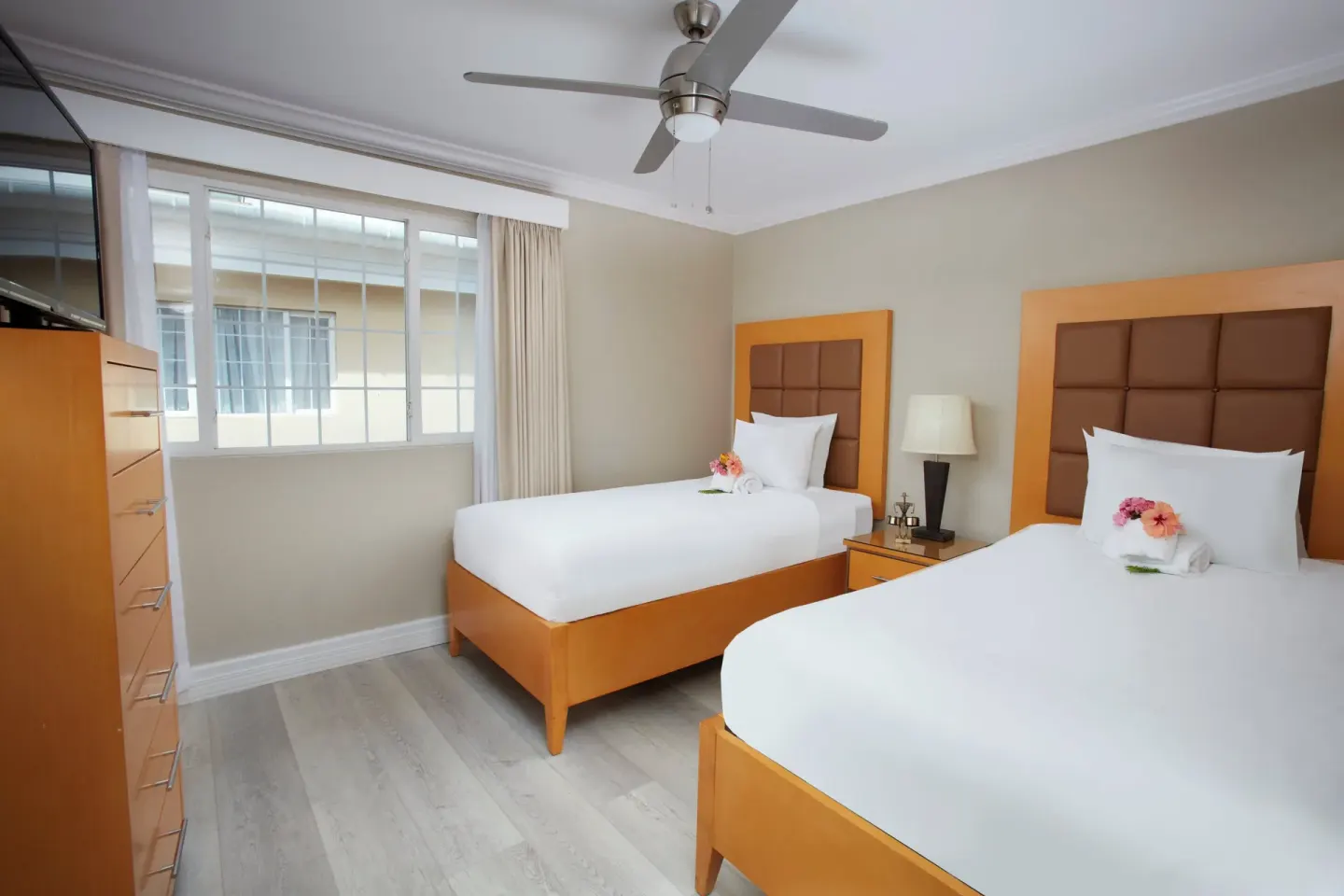 Twin bedroom with two beds and a dresser in a two-bedroom suite at Divi Southwinds Beach Resort.