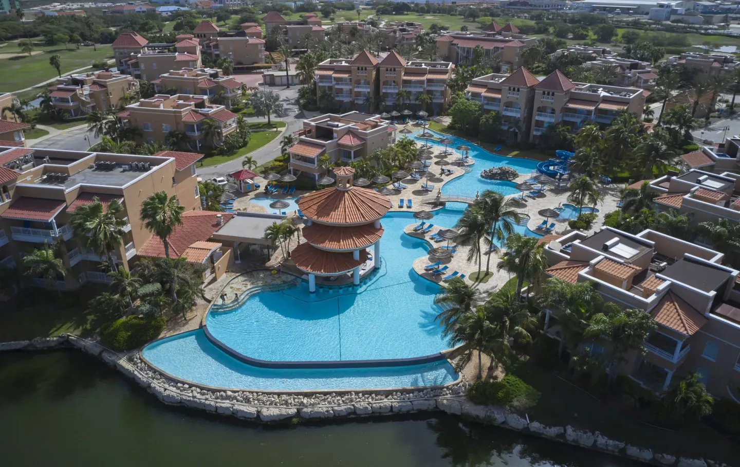 Aerial view of pools, buildings, and lagoon at Divi Village Golf & Beach Resort.